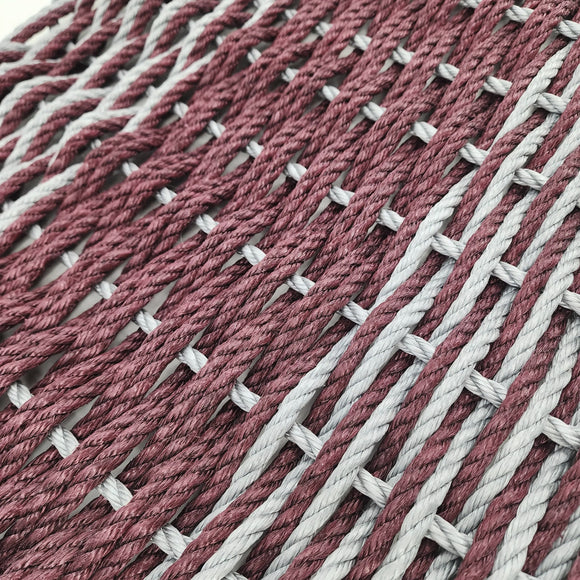 Close-up of interwoven red and white yarn on a textured surface