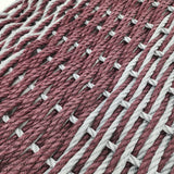 Close-up of interwoven red and white yarn on a textured surface
