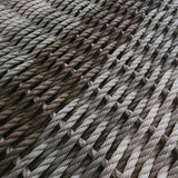 Close-up of woven rope mat with natural color gradient on a dark background