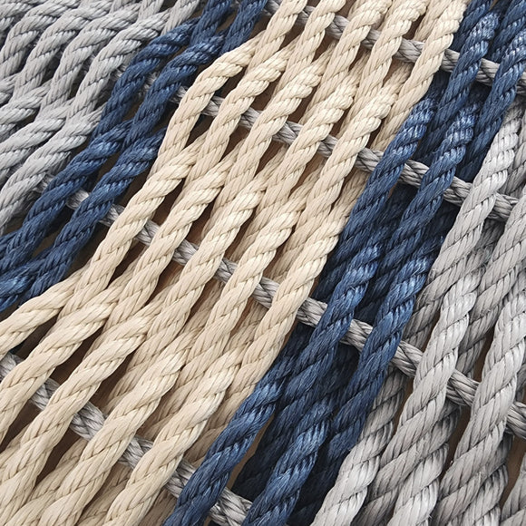 Close-up of braided ropes in various colors including blue, beige, and gray.