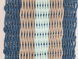 Woven pattern with blue, beige, and green threads on a beige background