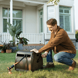 Man using a Garden Hose Reel Box-Heavy Duty outdoors in front of a house