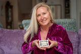 Woman in a purple velvet shirt holding ALMOND MILK SOAP 5 oz. ~ INFUSED WITH ARNICA