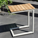 Wooden table with white metal frame on a tiled outdoor floor