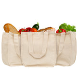 Three beige tote bags filled with groceries on a white background