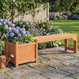 A wooden garden bench with an integrated planter box, shown in a landscaped backyard garden on a stone patio with flowers, a watering can, and a wooden fence in the background.