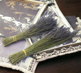 Two bundles of lavender on a decorative surface with a floral pattern.
