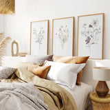 Decorative bedroom with 3 Piece Watercolor Floral Wall Art Set pillows, and a lamp.