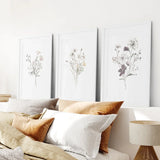 Decorative pillows on a sofa with 3 Piece Watercolor Floral Wall Art Set in the background