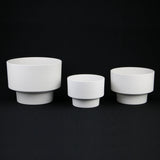 Three white ceramic bowls of different sizes on a black background 3-Piece White Plastic Planter Pot Set – Modern Pedestal Base