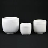 3-Piece White Stoneware Planter Pot Set with Vertical Line Texture on a black background