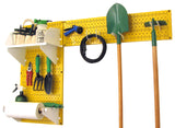 Yellow pegboard with various gardening tools hanging on it against a white background