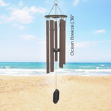 Pacific Winds Series Wind Chime labeled 'Ocean Breeze 36"' on a beach with ocean view
