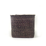 Woven basket made of black and brown materials on a white background