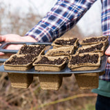 Person holding a tray of CowPots® Starter Kit
