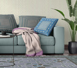 Living room with a teal sofa, blue pillow, and patterned rug.