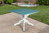 Teal table with white base on a patio