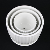 3-Piece White Ceramic Planter Pot Set with Vertical Fluted Design & Matching Saucers stacked on a black background