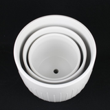 Set of three white ceramic bowls stacked on a black background