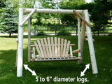 Wooden swing with 5 to 6 inch diameter logs in a grassy area with trees and a fence in the background.