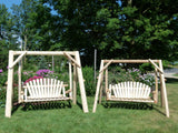 Two wooden swings in a garden setting with trees and flowers in the background.