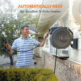 Man using an automatically neat product to manage a coiled hose outside a house.