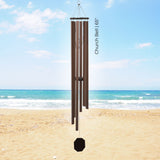 Brown Pacific Winds Series Wind Chime on a sandy beach with ocean and blue sky in the background