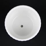 White plastic cup with a central hole on a black background