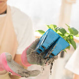 Person holding a blue plant pot with roots showing, wearing pink gloves.