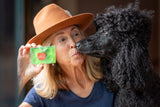 Woman in a brown hat kissing a black dog while holding a CRISP APPLE SOAP SLICE 5.5 oz.