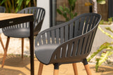 Gray outdoor chairs and table with plants in the background