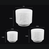3-Piece White Stoneware Planter Pot Set with Soft Vertical Texture on a black background