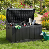 Black garden tool storage box with gardening tools and gloves on a grassy area with flowers in the background