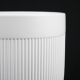 Close-up of a 3-Piece White Stoneware Planter Pot Set with Vertical Line Texture with ribbed texture on a black background