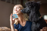 Woman holding COCONUT LIME VERBENA GOATS MILK SOAP SLICE 5 oz. with a black dog sitting next to her