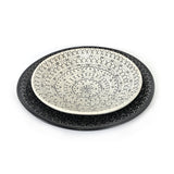 Decorative ceramic plate with black geometric pattern on a white background