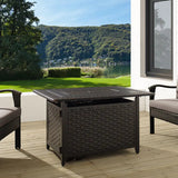 Outdoor patio setting with a fire pit table and chairs on a wooden deck.