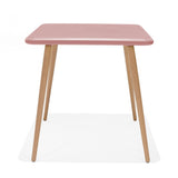 Small square table with pink top and wooden legs on a white background