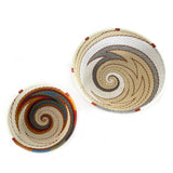 Two woven baskets with spiral patterns on a white background