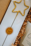 Gold star-shaped object on a white surface with a brand logo.