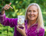Woman holding a product labeled 'Saltwater Tub' outdoors with greenery in the background