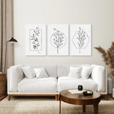 Modern living room with a white sofa, wooden coffee table, and Minimal Flower Line Art: Black White Wall Art Set.