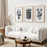 Modern living room with a white sofa, wooden coffee table, and framed Flower Market Black and White Art Set Decor on the wall.