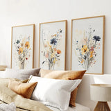 Neutral Watercolor Wildflower Art Prints Set on a wall above a sofa with pillows.