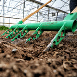 Green Broadfork being used on soil in a greenhouse setting