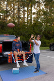 Two people playing with a football on a car trunk on a Basic Blue & White mat