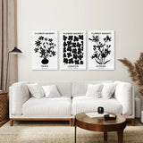 Living room with a white sofa, coffee table, and wall art featuring Flower Market Black and White Art Set Decor
