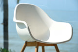 White chair with wooden legs against a blurred natural background