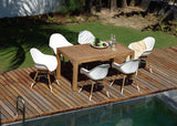 Outdoor dining set with table and chairs on a wooden deck by a pool