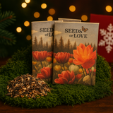 Two packages labeled 'Seeds of Love' with floral design on a green surface with blurred lights in the background.